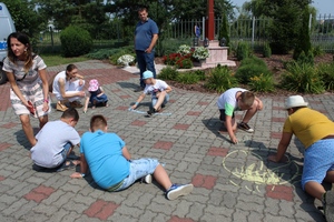 Dzieci rysują kreda po chodniku
