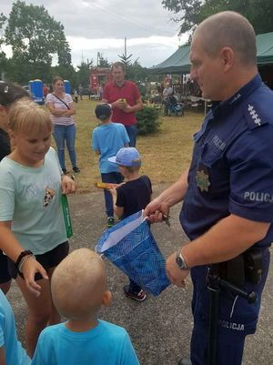 Dzielnicowy częstuje dzieci słodyczami