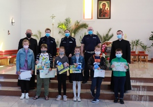 Policjanci i dzieci z nagrodzonymi pracami