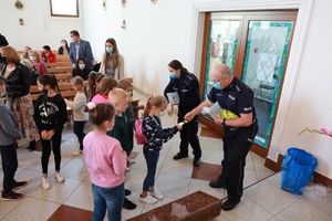 Policjanci wręczają dzieciom książeczki