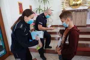 Policjanci wręczają dzieciom odblaski