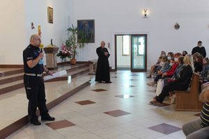 Policjant omawia zagadnienie jazdy samochodem przez dzieci jako pasażerów