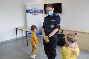 policjantka stoi przy niej dwie dziewczynki oglądają mundur