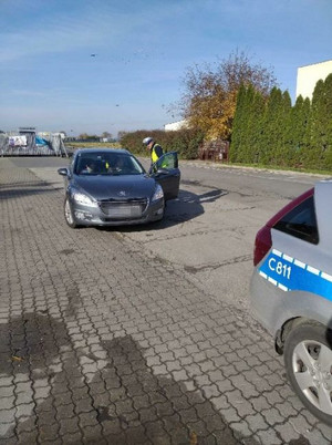 policjant kontroluje oświetlenie pojazdu