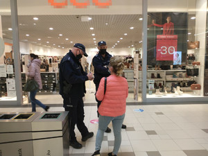 policjanci legitymują kobietę w galerii