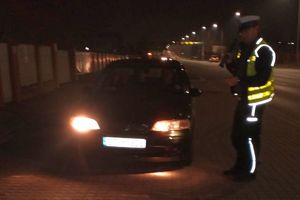 Policjant stoi przy samochodzie