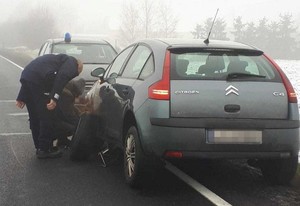 policjant pomaga zmienić koło w aucie