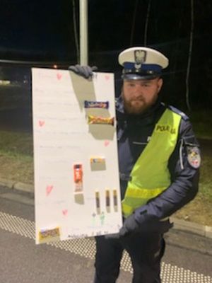 Policjant trzyma plakat od dzieci