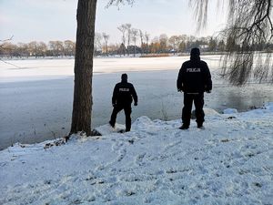 policjanci stoją na brzegu jeziora