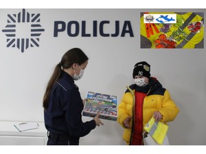 Chłopiec odbiera od policjantki gratulacje i upominek