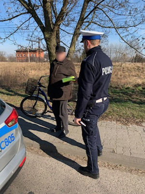 zatrzymany senior na rowerze otrzymuje kamizelkę
