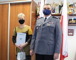 pracownica przechodząca na emeryturę i komendant powiatowy policji na wspólnym zdjęciu