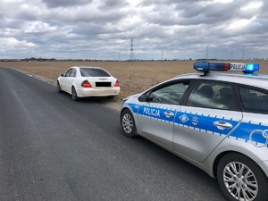 samochód osobowy i za nim zaparkowany radiowóz