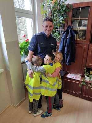 policjant z dziećmi w kamizelkach