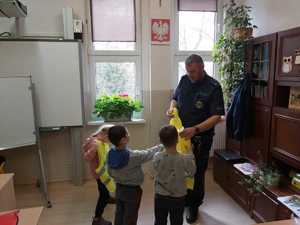 policjant zakłada dzieciom kamizelki