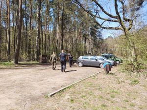 służby kontrolują pojazdy zaparkowane przy lesie