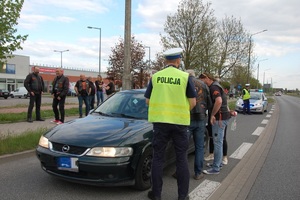 policjant stoi przy pojeździe