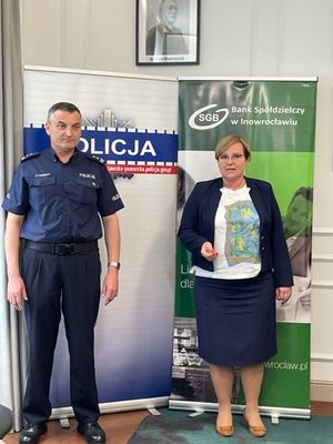 Komendant Policji i Prezes Banku stoją na tle banerów