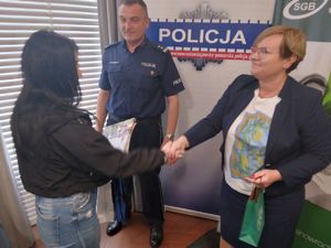 Prezes Banku wręcza kobiecie nagrodę