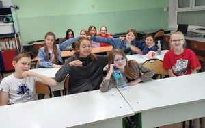 dzieci siedzą w ławkach