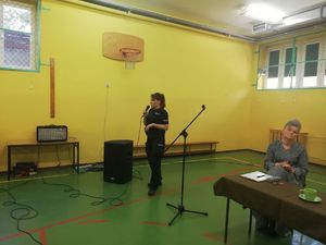 policjantka przez mikrofon mówi do uczniów