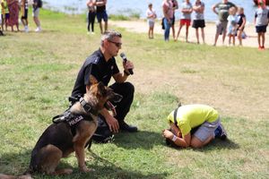 policjant z psem i dziecko pokazuje postawę żółwika
