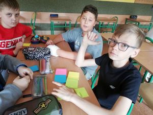 dzieci w klasie piszą na karteczkach informacje