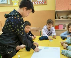 dzieci w klasie wypełniają kartkę bristolu wiadomościami