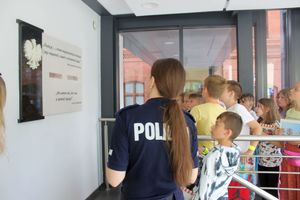 policjantka i dzieci przy tablicy pamiątkowej