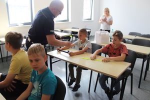 policjant pokazuje wyposażenie do służby