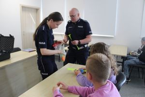 policjantka wręcza dzieciom odblaski