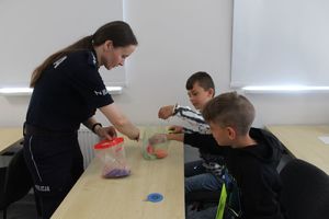 policjantka rozdaje dzieciom gadżety