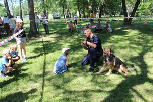 policjant pokazuje dziecku jak chronić się przed groźnym psem