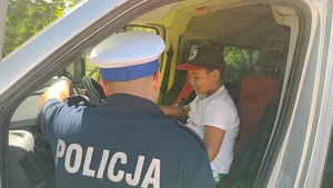 policjant z dzieckiem siedzącym w radiowozie