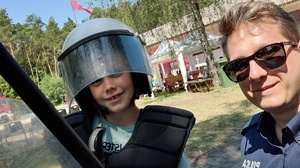 policjant z dzieckiem w hełmie policyjnym