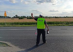 policjant daje sygnał do zatrzymania się