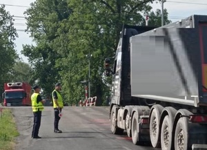 policjanci stoją przy pojeździe ciężarowym