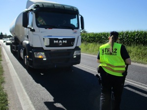 pojazd ciężarowy i policjant