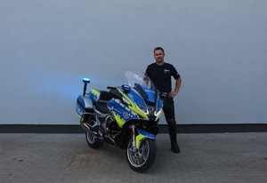 policjant stoi przy motocyklu