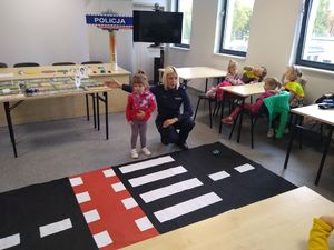 policjantka uczy dziecko przechodzić przez pasy