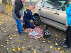 policjant podczas naprawy pojazdu