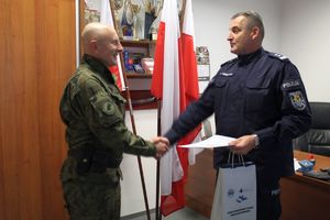 komendant wręcza leśnikowi paczę z upominkami