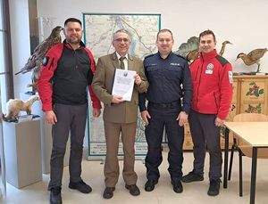 cztery osoby stoją, jeden trzyma podpisaną analizę