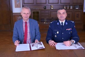 prezydent miasta i komendant siedzą przy biurku i przed nimi porozumienie