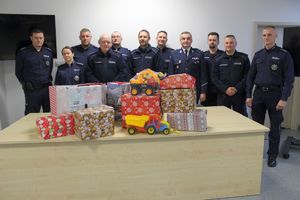 policjanci stoją przed nimi stół z podarunkami