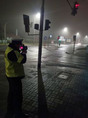 widok na policjanta z miernikiem prędkości i skrzyżowanie