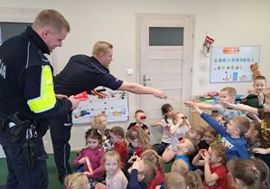 policjanci wręczają dzieciom odblaski