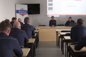 widok na policjantów w sali i prowadzącego spotkanie