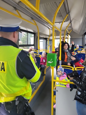 policjant rozmawia z dziećmi siedzącymi w autobusie