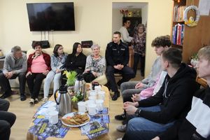 policjant przekazuje informacje seniorom